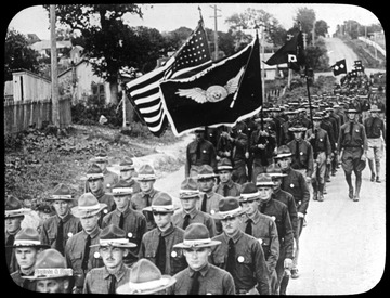 World War I Lantern Slide Show. Slide No. 08 in group of originally numbered slides.  American soldiers marching with flags.  Frame is labelled with text saying 'Visual Bureau, University of Pittsburgh.'  (negative no. 8-12199 is inscribed on slide)<br />