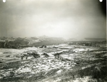 'Morgantown Ordnance Works, Morgantown, W. Va. Photograph Number 101. General View of plant site with main construction office and parking area in foreground. Factory area and temporary shops in background. Taken from hilltop Northwest of plant. January 31, 1941, 11:00 A.M.'