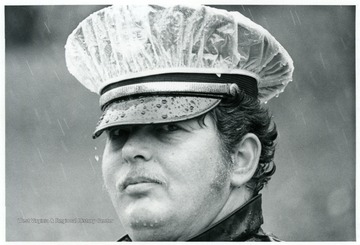 Man in a police hat in the rain.