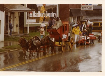 A horse drawn wagon is followed by a young boy on a tractor during the Monongalia County Bicentennial Parade in Morgantown, West Virginia.