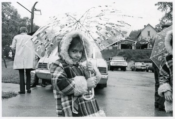 A small girl holds an umbrella.
