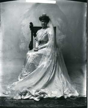 A bride is sitting in a chair.