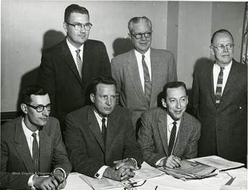 Group of men sitting and standing. Man on the far right is 'Dr. Fred Boyers'. 