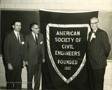 Three men with a banner.