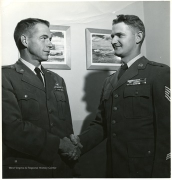 'Major L. M. Legge, left, Operations Squadron Commander at the USAF Academy, Denver, Colorado, congratulates Airman James R. Boone on his promotion to the rank of Technical Sergeant. Technical Sergeant Boone, son of Mr. and Mrs. Paul Boone, 1962 Chancery Row, Morgantown, West Virginia attended University High School. He has a total of eleven years of service. and was assigned to the United States Air Force Academy on a three year tour of duty in 1955.''Air Force Photo'.