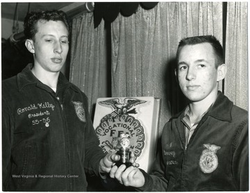 Ronald Kelley, President, holds an award with David Rowan.