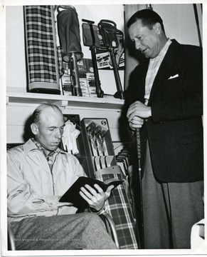 '98-305-1/AI-57: Aberdeen Proving Ground, Maryland. Sgt. Arthur Purdue, Serv and Serv Det U.S. Army Garrison, who takes care of the Clubhouse at Special Services Golf Course, APG, Maryland, spends his free moments reading his Bible. He is shown reading a passage to Mr. Lawrence Wisner, the APG Golf Pro. U.S. Army Photo, Photographer-Noel. Please credit as U.S. Army Photograph.'