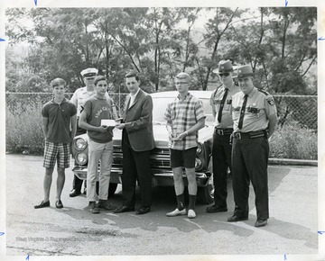 Winners of Road-E-O pose with police officers in this photograph.