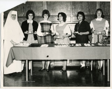 Vincent Palotti Hospital Candy Stripers pose with plates with food.