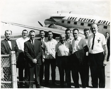 The Douglas DC-3 in the picture is owned by Lake Central Airlines.  Man second from left is Wm. Robinson.
