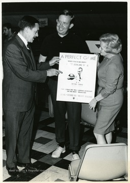 Terry Thomas and Jack Fleming with an unidentified woman at a bowling alley.