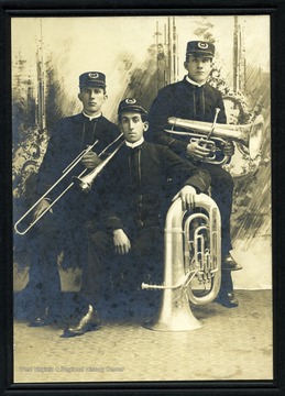 Three members of a band holding their musical instruments.