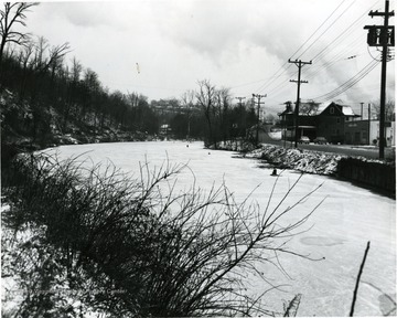 South University Avenue near city limits and Cobun Creek in winter. The buildings along the road are Morgantown Hydraulics, Dwelling, Core's Grocery, and the last house up the hill is the Bruce Ross House.