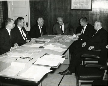 Morgantown's school board members. At the head of the table is Scott H. Davies and on the far right is Wilbur V. Bauer.