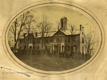 People are gathered in front of Monongalia Academy in Morgantown, West Virginia. 'Erected in 1829, destroyed by fire , January 11, 1897."