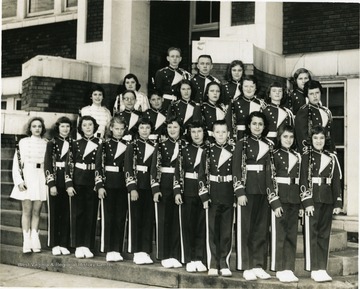 View of the members of the Morgantown Junior High School band in uniforms holding their clarinets.  Identified, front row, left to right: Eloise Feola, Dixie Casteel, Carolyn Jacobs, unknown, Susan Feather, three unknowns, Cindy Hollandsworth, Judy Douglas, Suzy Brown.  Second row, second from left is Bill Rader, second from right is Suzy Pauley, far right, Jennifer Jacobs.
