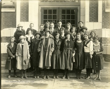 Members of the English Club pose for a group portrait in front of their school.