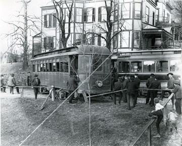 Several men and two little boys survey the results of a streetcar accident