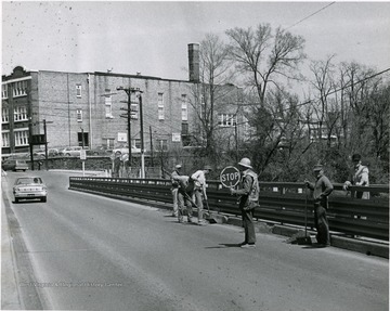 Men at work repairing Walnut Street Bridge. Morgantown Junior High School visible in the background.