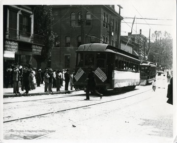 Passengers are boarding and departing streetcars along High Street in Morgantown, West Virginia.