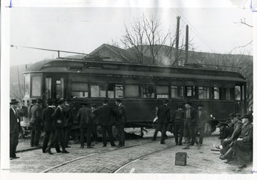 Passengers are standing in front of the Sabraton Streetcar which has derailed in Morgantown, West Virginia.