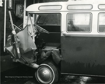 A wrecked VW Microbus. The front end is completely smashed in.