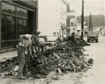 Men digging up the sidewalk on Beechurst Avenue between about 3rd and 8th Street.