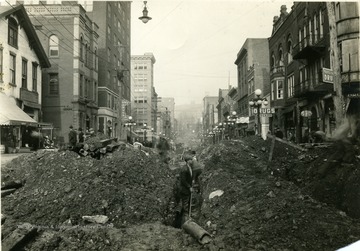 A view looking North of men excavating High Street for new pipelines.