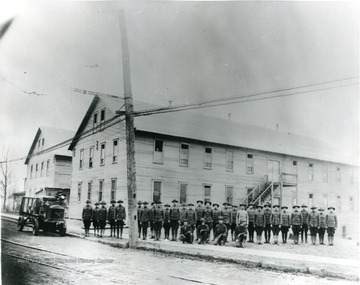 World War I trainees at attention in front of barracks.