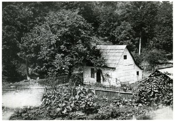 'House has wood shingles.  Original photo owned by Clyde Moneypenny who was born here in 1884. - still living today, August 25, 1977.'