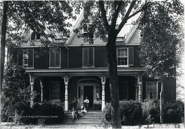 A view of O. B. LeFevre's home in Bunker Hill with people sitting on the porch.