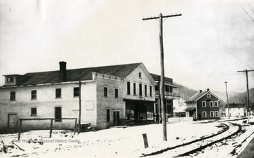 A view of the Meadow River Lumber Company Building (in the foreground), a bank, and an office building in Rainelle. The Sewel Valley Depot is to the right. 