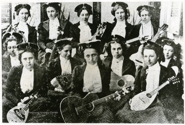 Group portrait of female members of a Mandolin and Guitar Club with their instruments.