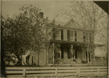 View of a small girl and dog on the front porch of the Delay House in Petersburg, W. Va.