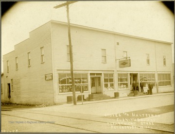View of four men in front of Groves and Halterman Furniture and Department Store from across the street, Petersburg, W. Va. 'Harmen Groves, F. E. Harman, Wilbur Heach'