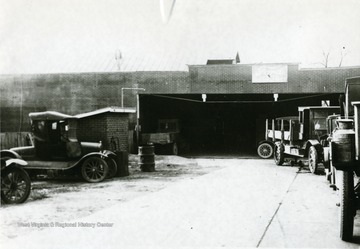 View of Bean's Garage, Moorefield's first garage. 'In 1909 M. A. Bean, a farm boy from 'up the river', came to town and started a livery stable at the present location of Bean's Garage (1954). In 1911 he bought a high wheeled International Automobile and started in the taxi business. In 1912 he bought a Buick and added it to the taxi service. It was in 1912 that he also got the Ford Dealership in Moorefield and started to sell automobiles, and installed his first gasoline pump. In 1918, Mr. Bean got the Gulf Distributorship for several counties in this section. Until 1952 part of the old original livery stable still housed part of the garage. In one year during Bean's Garage history they sold 380 automobiles which was their record year.'