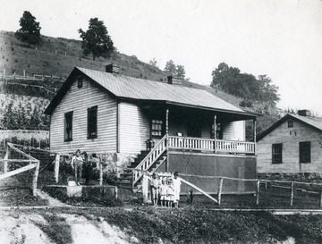 Children stand outside of a miner's home in Harrison County.