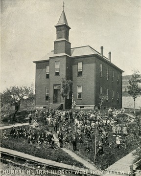 View of the original Salem College building with people 'several with bicycles' crowded on the lawn. 'Hurra! Hurra! Huree! we're from Salem C:'