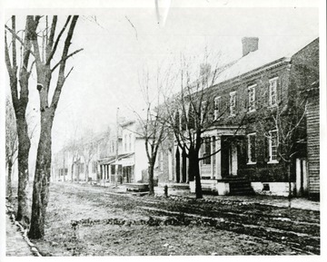 View of 'Main Street Looking North from Opposite McCoy Theater site in 1909: Building at right was then Turley Hotel, Frame building extreme right- Miss Luch Williams Home White store building with roof extending out over street - Bowen Drug Store.'