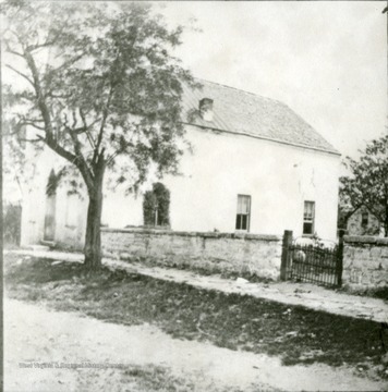 View of the Old Episcopal Church, now the Asbury Methodist Church, and a wall surrounding the old Episcopal graveyard.