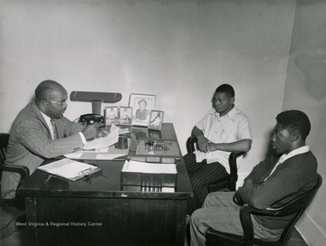 Two young African American men sit in an administrative office at the West Virginia Industrial School for Colored Boys in Lakin.