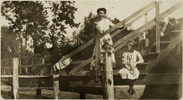 Helen Ballard, May Peck, and Maggie Ballard in order from left to right on a set of steps.