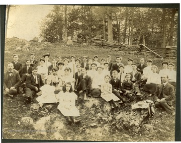A group portrait of Professor Lacey's High School, Rocky Point Academy, at Sinks Grove, Monroe County, West Virginia. 'Identification by Carlos Parker son of Anna Steele Parker, 8/1979 (nearly blind) at Roanoke.  Taken to him by Va. Steele. Prof. Lacey at far right, in front.  Man in suit, center right with coat buttoned to neck is Robert Morton Steele.  Eva B. Steele on his left. Steele's born in Steele's Valley (Steelesburg) Tazewell County, Va. near Cedar Bluff and moved to Monroe County.  First row, person with hat is Ollie Steele.   Boy and man front left is Ray P. Beckett and Mr. C. A. Keadle - teacher and superintendent of schools Monroe County.  Organized the corn clubs that were forerunner of 4H Clubs. Suggested at Farmer's Institute, Monroe County 1890-1900s.'