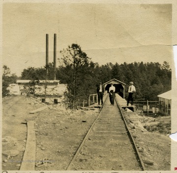 Three men are standing on the railroad tracks at the Sprague Mine in Raleigh County, West Virginia.