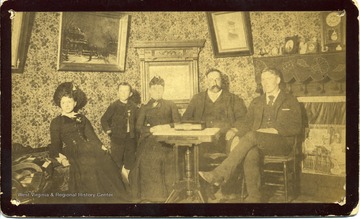 Parlor at Hull Hotel, 1895, Raleigh County.  In photograph: unknown, Flynn Hull, and first cousins Annie Prince and John S. Hull.