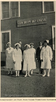 Group portrait of the superintendent and staff standing outside of the Crichlow Hospital.