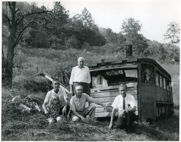A group of people stand in front of the old school bus.