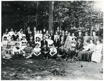 Group portrait of students near a wooded area.
