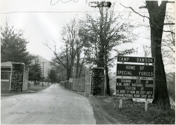 View of Camp Dawson gate.  Sign reads- 'Home of Special Forces.  Training site of W. Va. Army National Guard station of SV. BTRY. 1st HOW. BN. 201st ARTY. Organizational maintance shop number 4.'