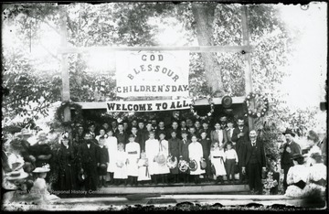 Signs say:  'God bless our children's day', 'Welcome to all'.